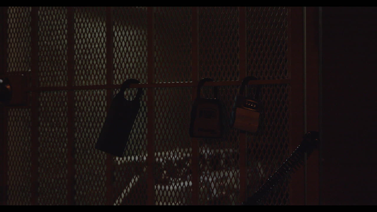 video de primer plano de la puerta cercada cerrada con tres candados de diferentes tamaños colgando de ella