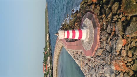 vertical shot of lighthouse in front of marina hilton garden inn hotel on the caribbean sea in la romana, dominican republic