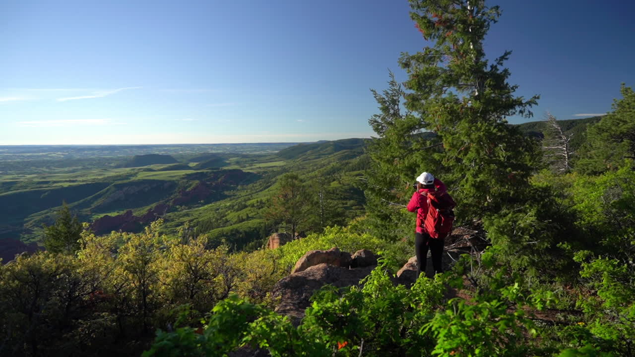 fotógrafo paisajista con mochila tomando fotos del impresionante parque estatal de roxborough, colorado, ee.uu., fotograma completo