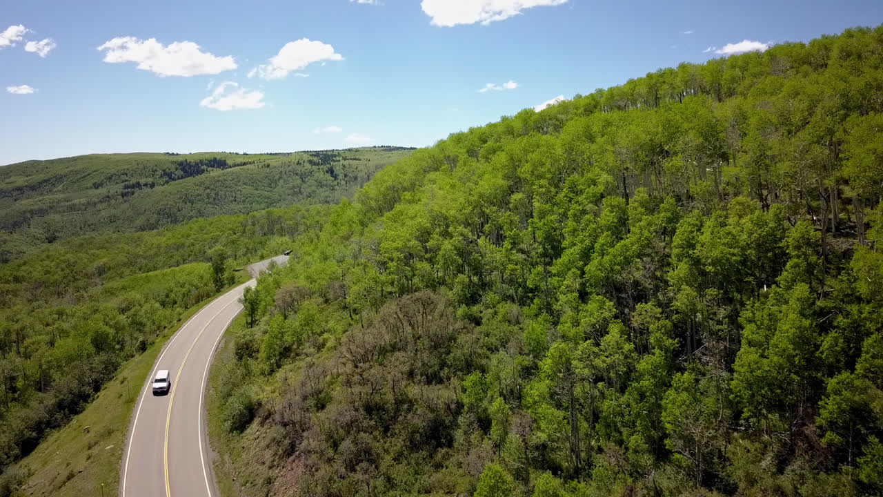 toma aerea, avanzando, carretera de montaña de colorado, vehículo desconocido moviéndose hacia el espectador