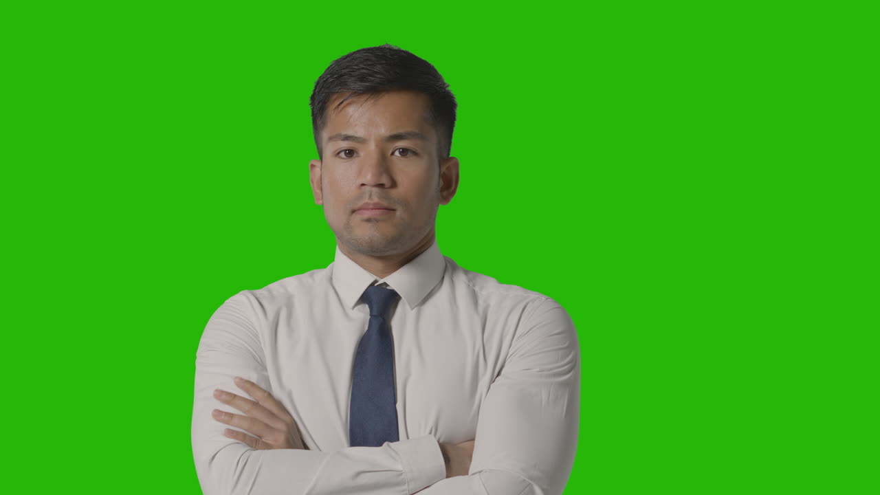 카메라를 보고 있는 녹색 화면에 셔츠와 넥타이를 매고 있는 진지한 사업가의 초상화