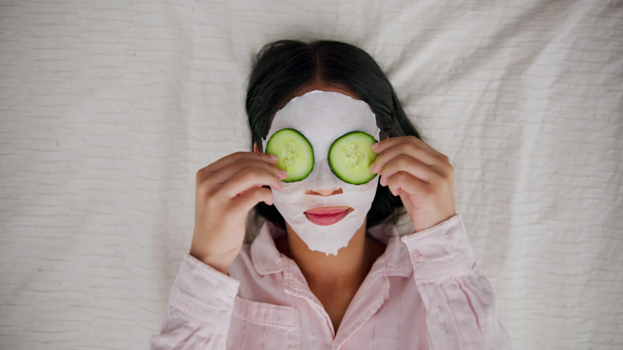 Woman with face mask and cucumber slices