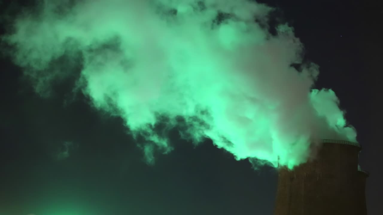 Green smoke from chimney of night industrial cityscape with carbon emissions from factory
