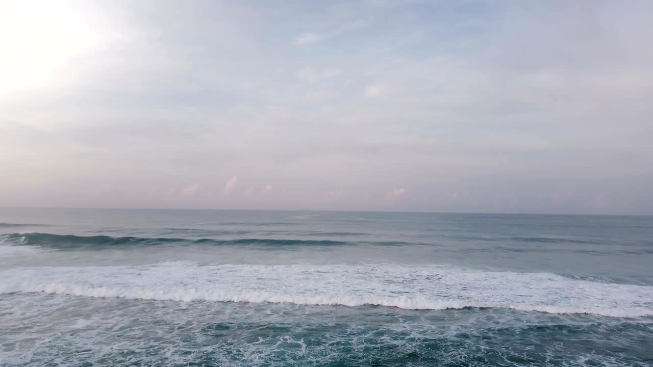 Aerial drone view of high waves in beautiful sunset ocean. Breathtaking open ocean, cloudy sky and horizon panorama