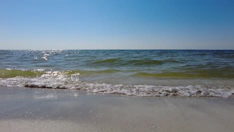 Waves-crashing-into-the-beach-on-a-warm-sunny-summer-day-in-Clearwater-Beach,-Florida