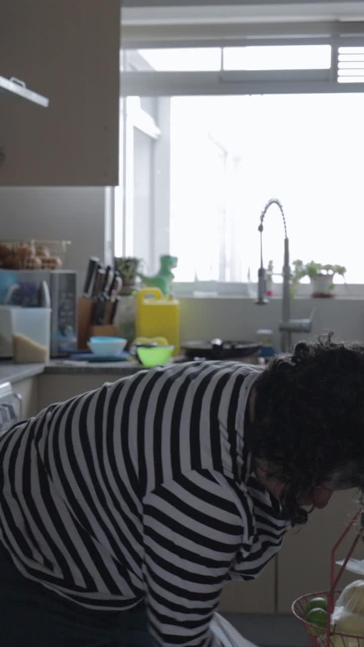Donna che Disfa la Spesa sul Bancone della Cucina