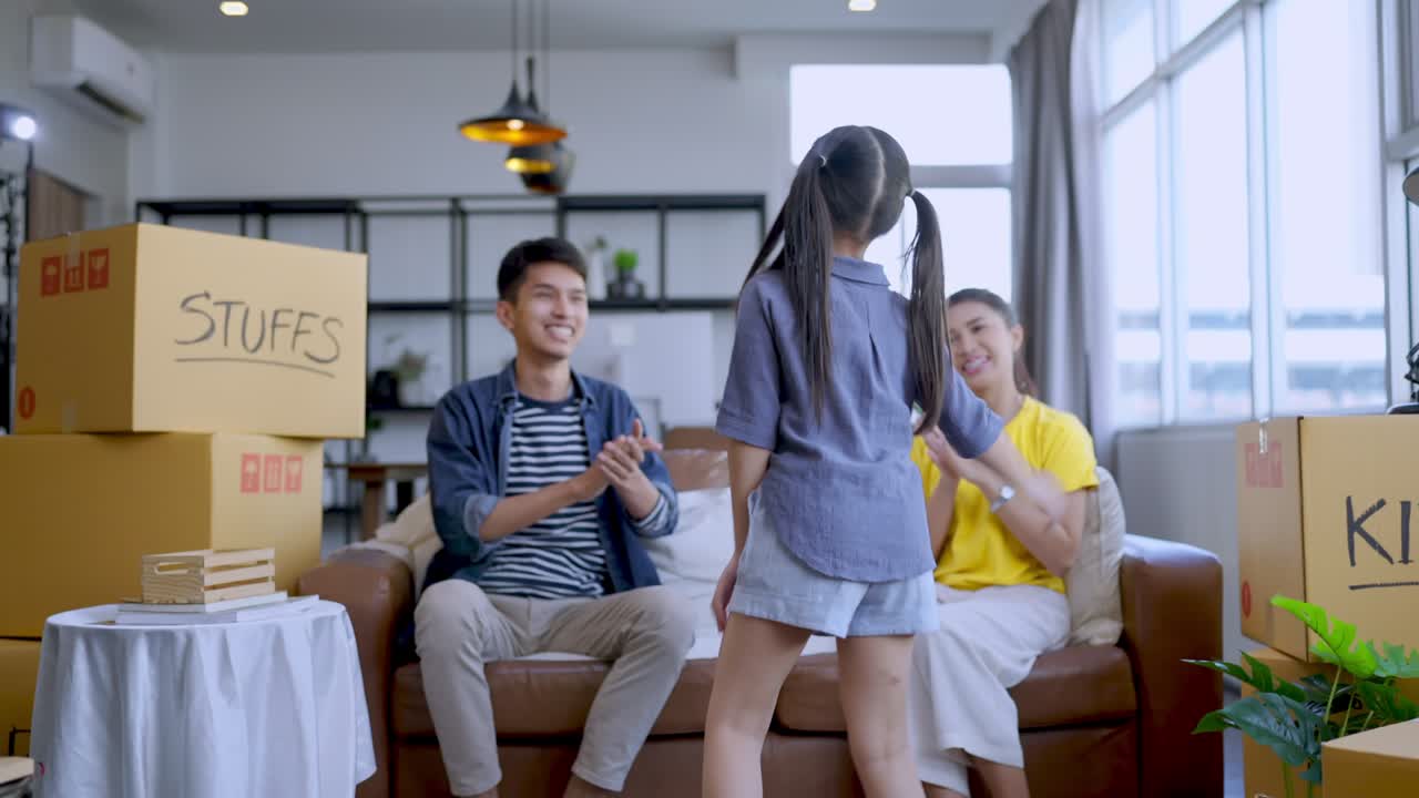 행복 아시아 딸 춤추는 그녀의 부모를 즐거운 재미있는 움직임으로 보여주는 동안 휴식을 취하고 카드 박스에 물건과 물건을 포장 한 후 집에 이사하는 아이디어 개념, 가족 집에서 집에서 포장