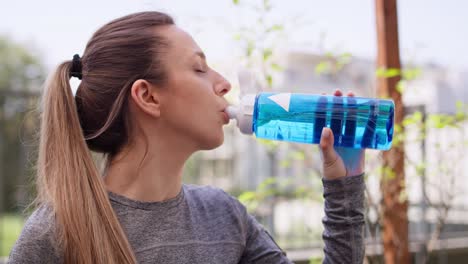 Pregnant-woman-drinking-water-after-home-workout.