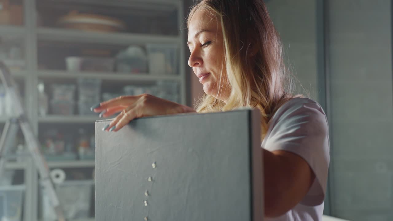 Frau bereitet eine Leinwand in einem Kunstatelier vor