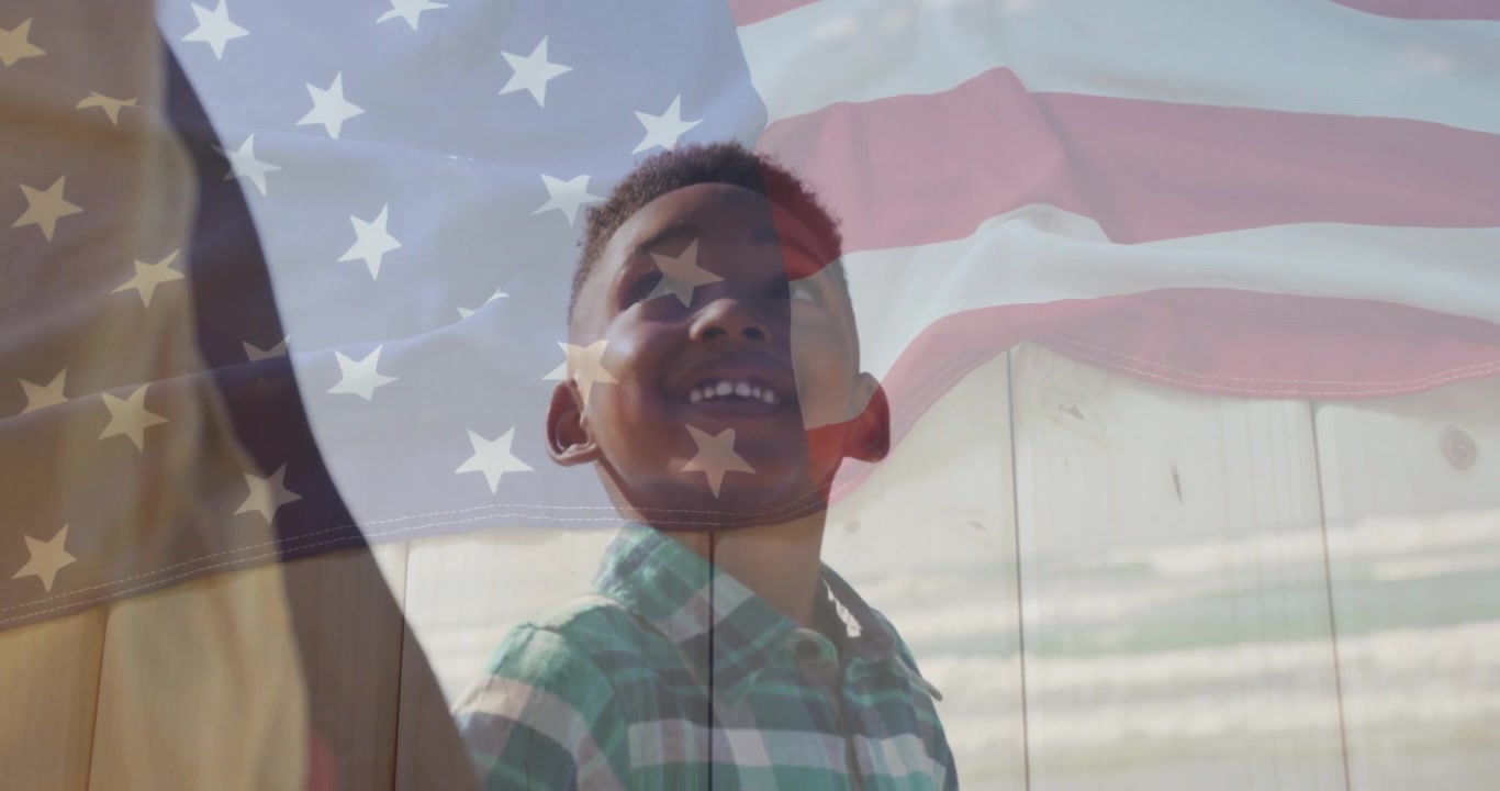 Un padre guida il figlio lungo un sentiero recintato, con la bandiera americana sovrapposta, il bambino sorride