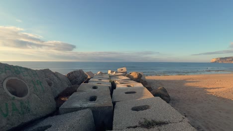 Walking-across-concrete-blocks-and-cubes-along-the-beach,-coastal-defense-structures-are-typically-used-to-protect-coastlines-from-erosion-and-wave-impact