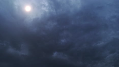 4k timelapse of the sun shining behind dark clouds in the sky