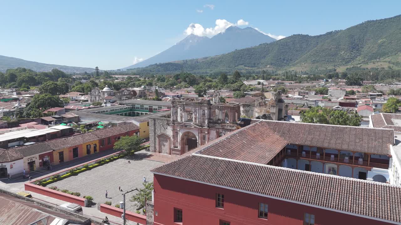 Aerial view of Antigua Guatemala showcasing historic ruins, colorful colonial buildings and Volcan de Agua in the background