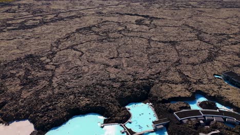 Tilting-revealing-shot-of-the-barren-landscape-surrounding-the-geothermal-spa-in-Reykjavik