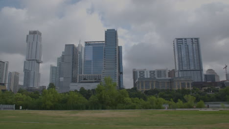 Schwenken-Sie-Von-Links-Nach-Rechts-Auf-Die-Skyline-Von-Austin,-Texas,-Mit-Menschen,-Die-In-Der-Ferne-Laufen-Und-Gehen