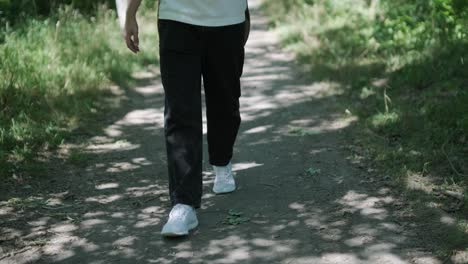 young man walking with guitar on street near forest