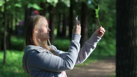 Young-woman-taking-a-picture-of-leaf