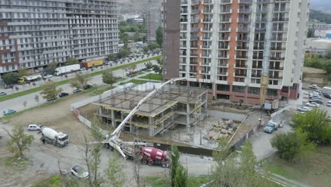 grúas móviles y camiones hormigonera en el lugar de construcción
