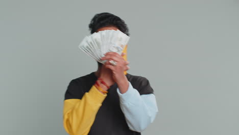 Indian man use smartphone rejoicing win receiving money dollar cash success lottery jackpot luck