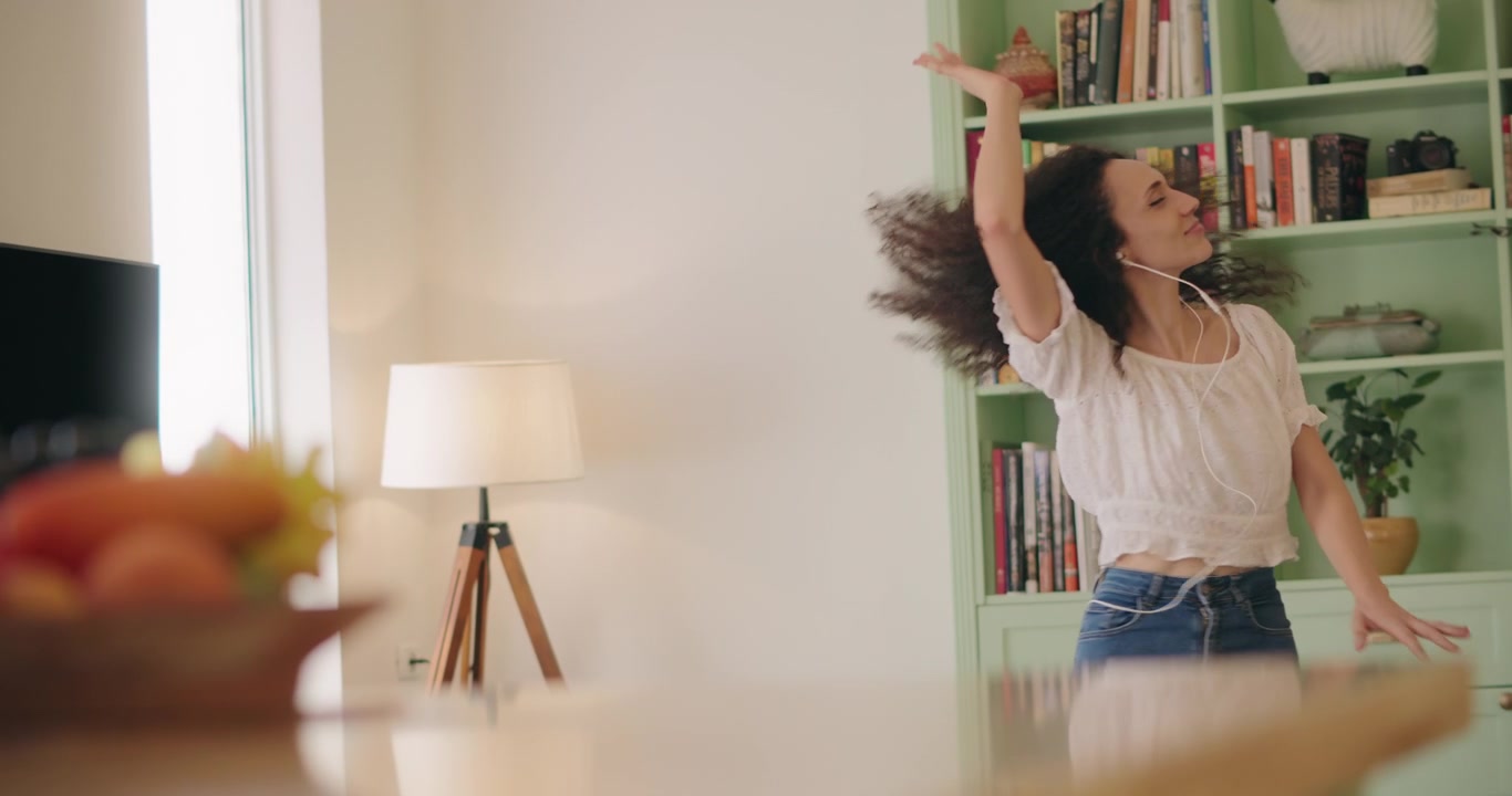 Mujer con cabello rizado bailando libremente