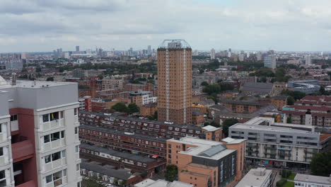 Forwards-fly-above-urban-neighbourhood.-Several-tall-buildings-towering-above-other-development.-London,-UK