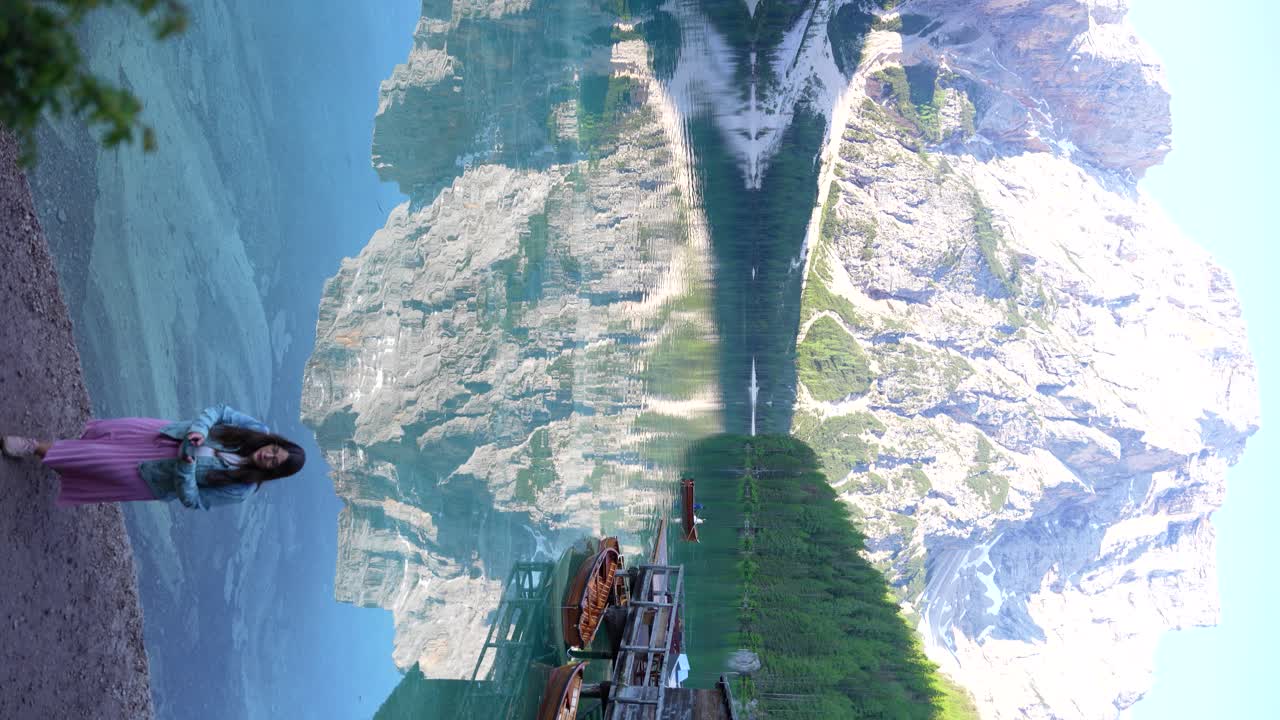 이탈리아의 lago di braies, dolomites에서  ⁇ 드폰으로 문자 메시지를 보내는 젊은 여성