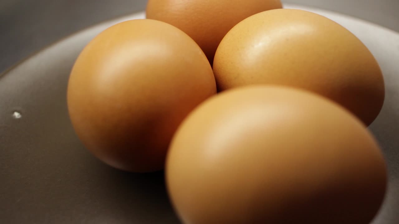 Dolly in to close up of four eggs on a plate