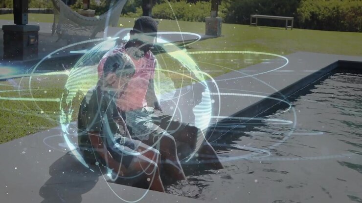 Parent and child dipping feet into water causing holographic globe spinning at pool for tech study