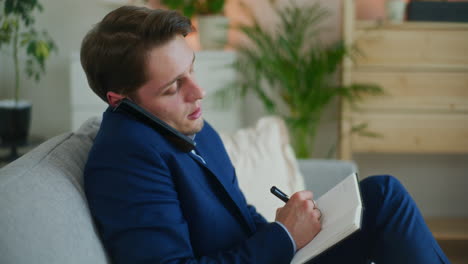 businessman notes while on phone