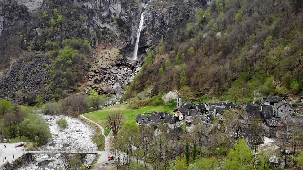 Letecký přelet nad vesnicí Foroglio v Ticinu, Švýcarsko, s výhledem na jeden z největších vodopádů Švýcarských Alp v pozadí starých kamenných domů.