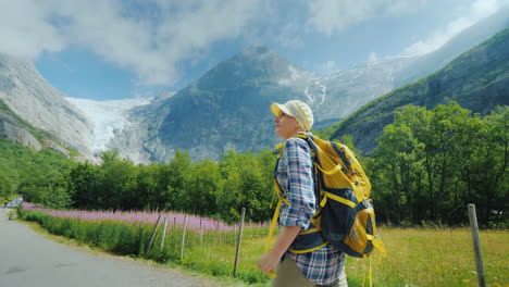 A-Woman-Walks-Along-The-Path-To-The-Briksdal-Glacier-In-Norway-A-Rear-View-Traveling-In-Scandinavia