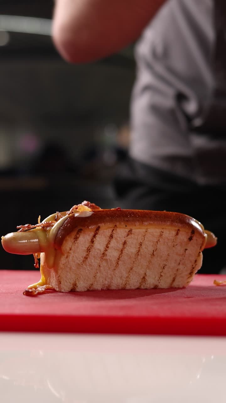 el chef preparando un perrito caliente