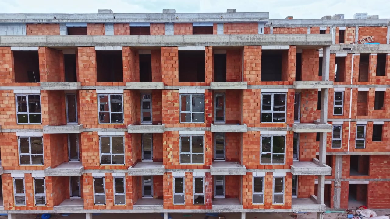 Canteiro de obras urbano. Edifício de apartamentos moderno em construção. Erguendo novo complexo residencial em meio a escombros. Progresso na habitação urbana com concreto exposto e andaimes.