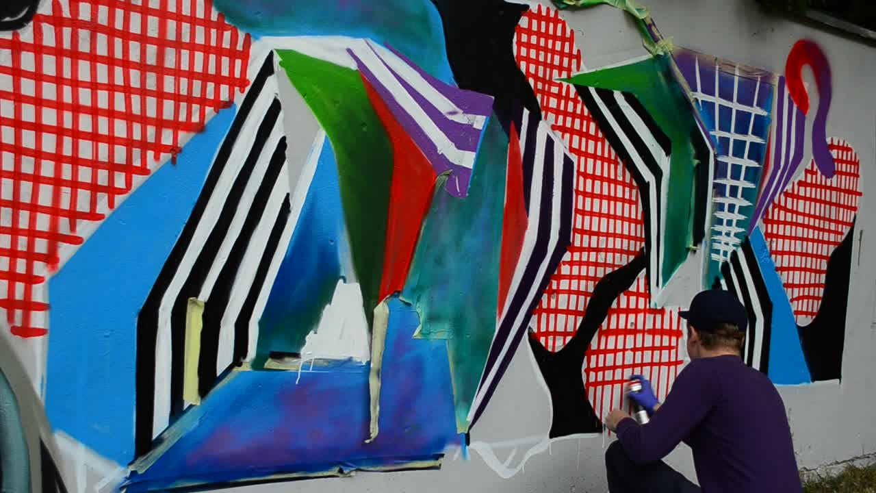 Processen med at skabe graffiti, hegn. Kunstneren tegner graffiti.