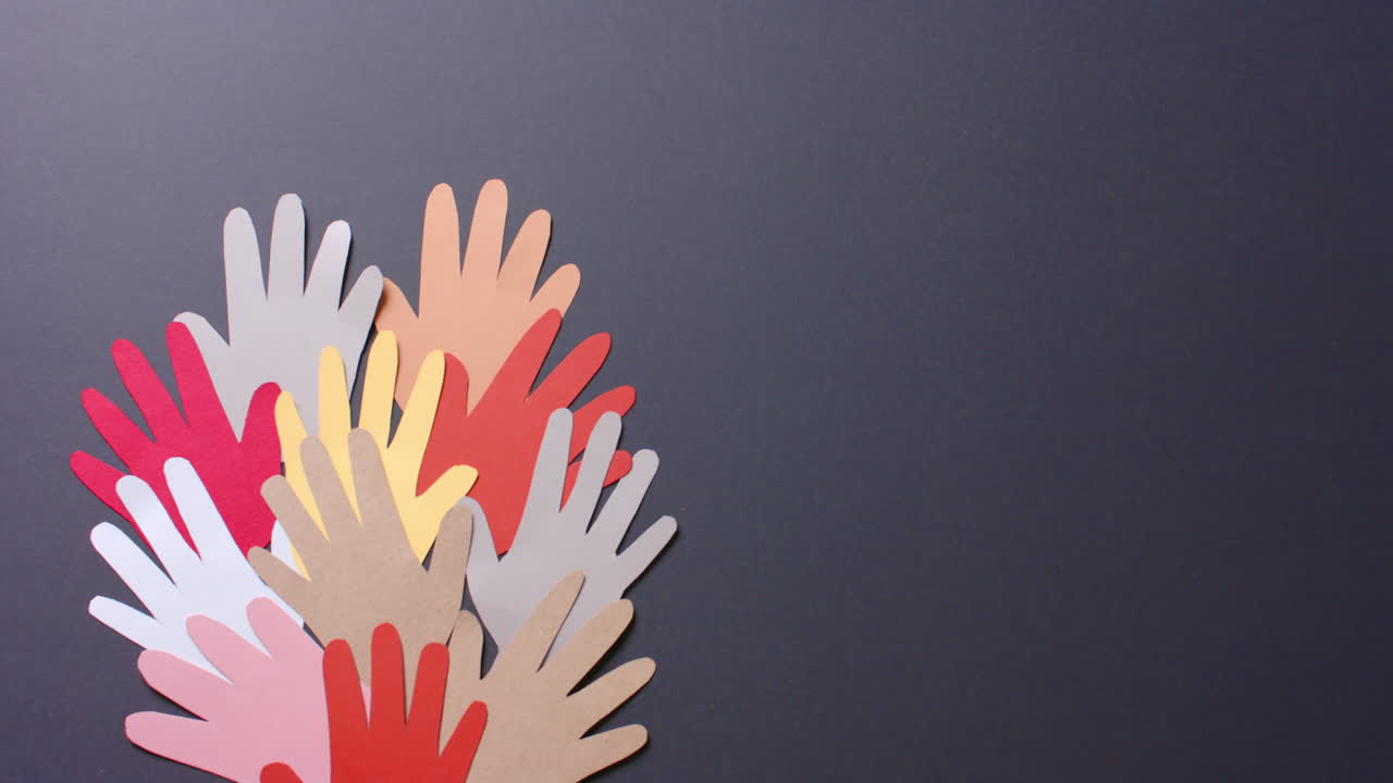 cerca de las manos juntas hechas de papel de colores sobre fondo gris con espacio para copiar