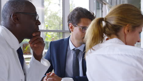 medical team having meeting sitting around table in hospital