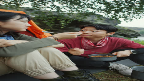 asian female tourists eating camping dinner