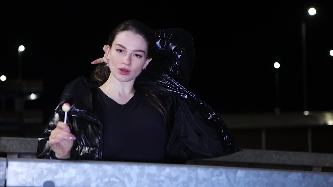 Close up young stylish woman moving and dancing in urban area at night