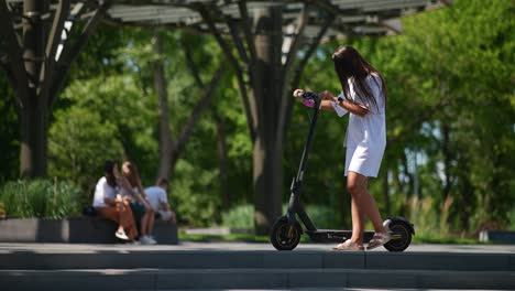 woman riding an electric scooter in a city park