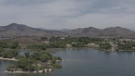 a beautiful aerial drone shot, drone flying towards the mountain lines in lake skinner - temecula - riverside county - california