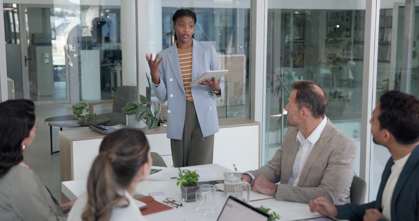 Young Businesswoman Presenting to Colleagues in Modern Office Meeting
