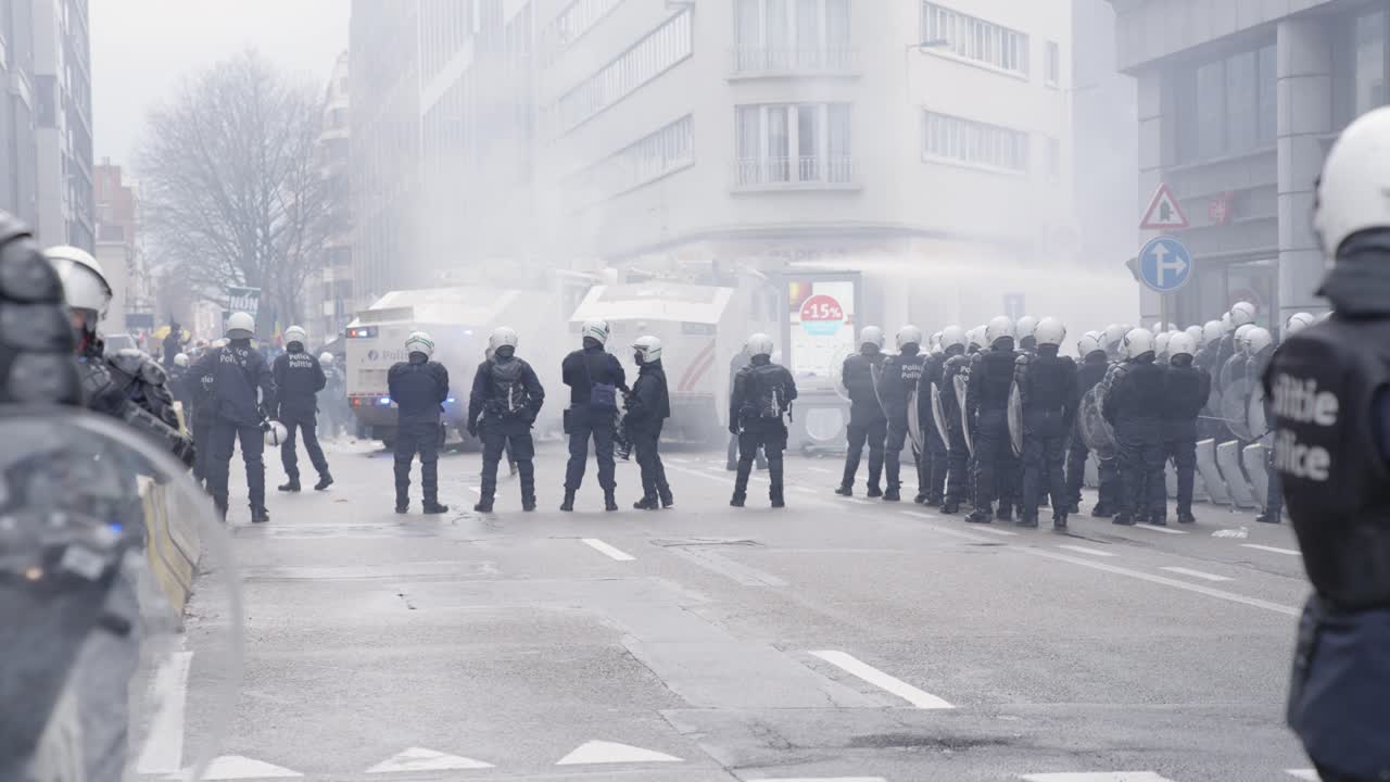 Gruppo di poliziotti che blocca la strada cittadina con equipaggiamento completo