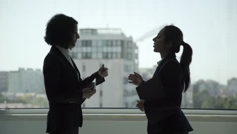 Smiling-businesswomen-talking-in-office