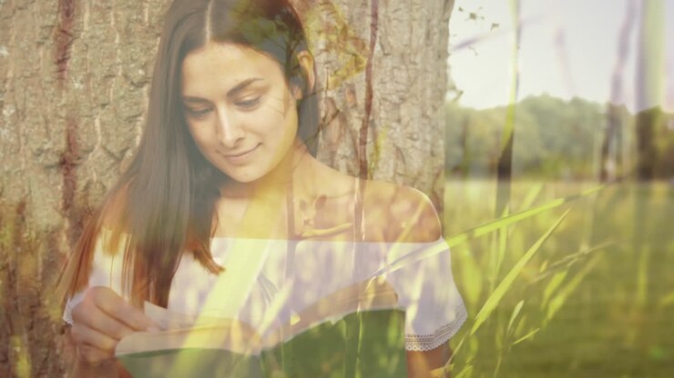 Donna che legge un libro sotto un albero