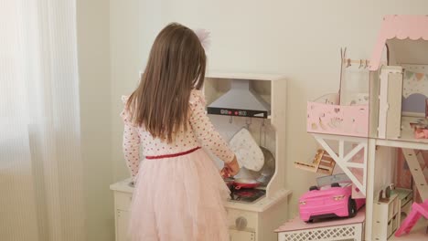 little girl playing in playroom in pretty dress