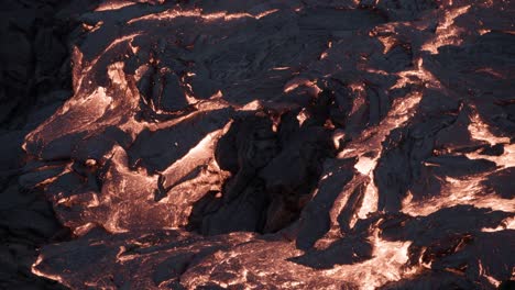 close up of molten rock flows calmly, hot lava solidifying slow at night