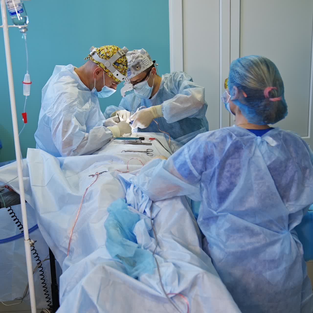 Thyroid surgery performed by a couple of surgeons in modern clinics. Two nurses helping the doctors at procedure