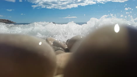 Slow-motion-footage-of-sea-splashing-on-stones-and-pebbles