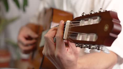 musician playing classical acoustic guitar, close up view of fingers on fretboard