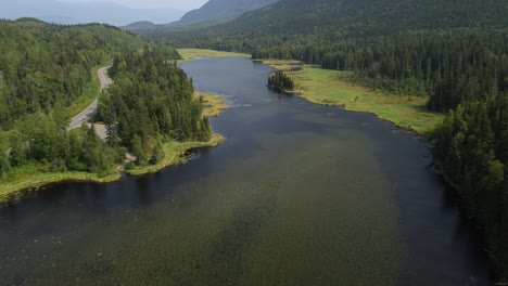 Aerial-Dolly-Tilt-Up-Shot-Across-Seeley-Lake-Provincial-Park-with-Alpine-Green-Forest-Trees-Covering-the-Scenic-Landscape,-Smithers-in-Canada